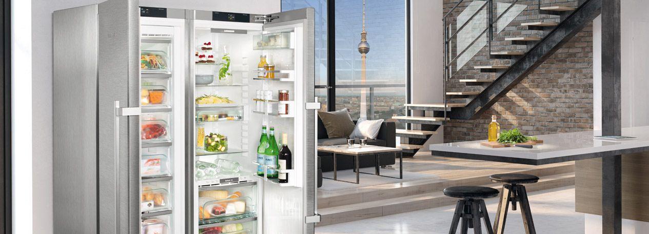 Liebherr Side-by-Side Kühl-Gefrierschrank geöffnet in heller Loft-Küche mit Berliner Fernsehturm-Blick