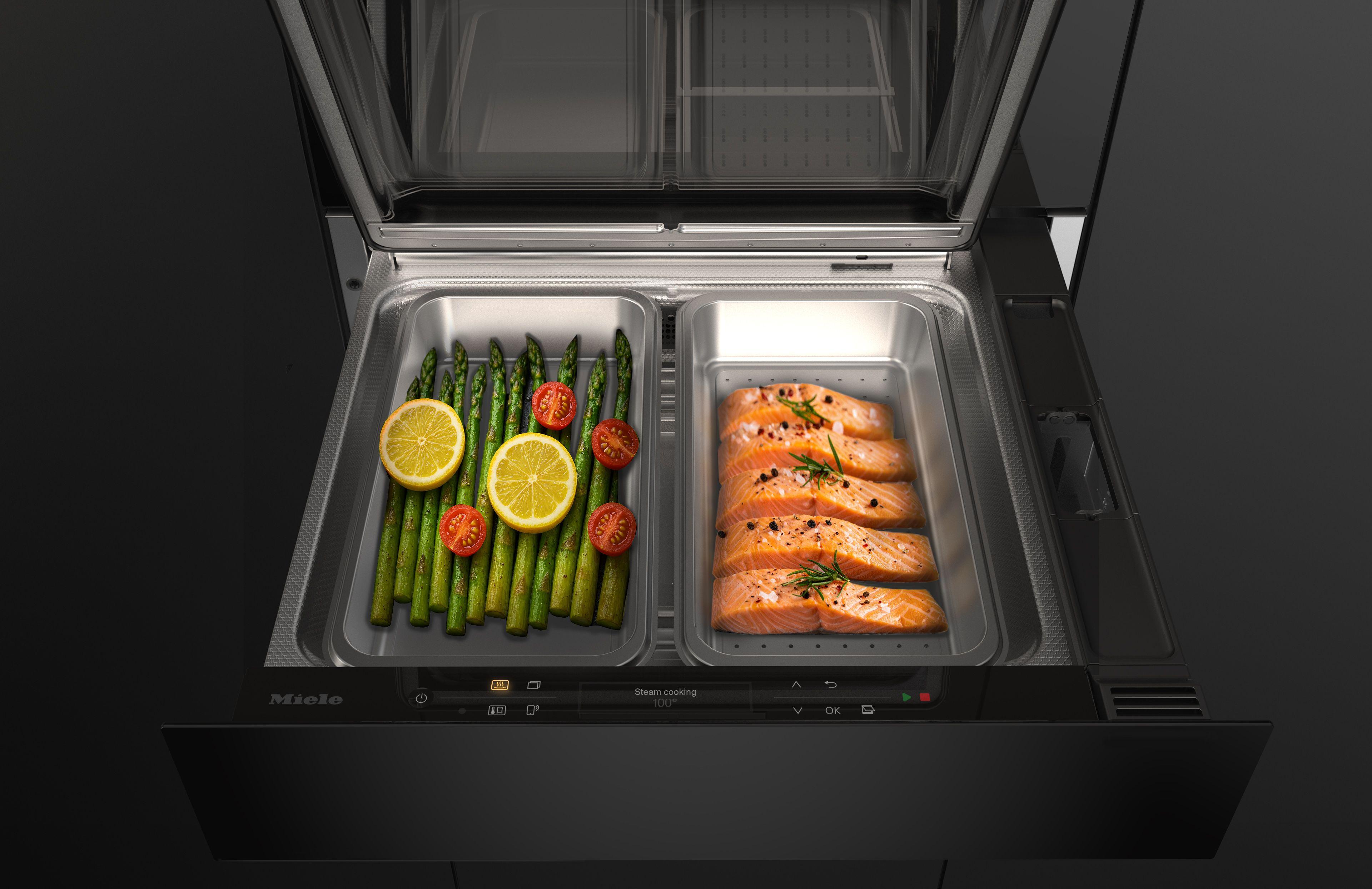 Miele Dampfgarer-Schublade mit zwei Garbehältern, gefüllt mit Spargel und Lachsfilets.