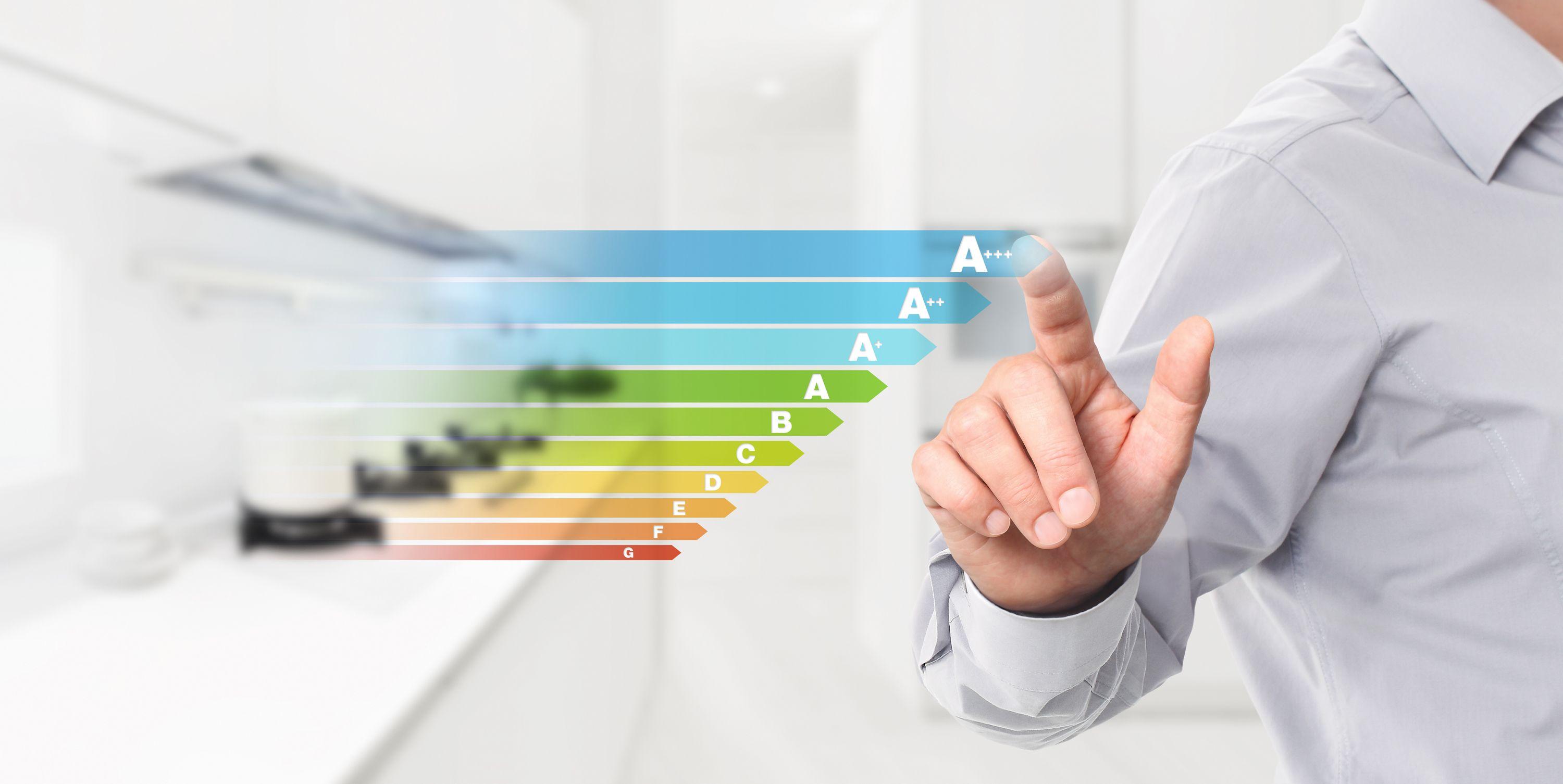 Hand zeigt auf Energieeffizienz-Skala A+++ bis G vor moderner Küche