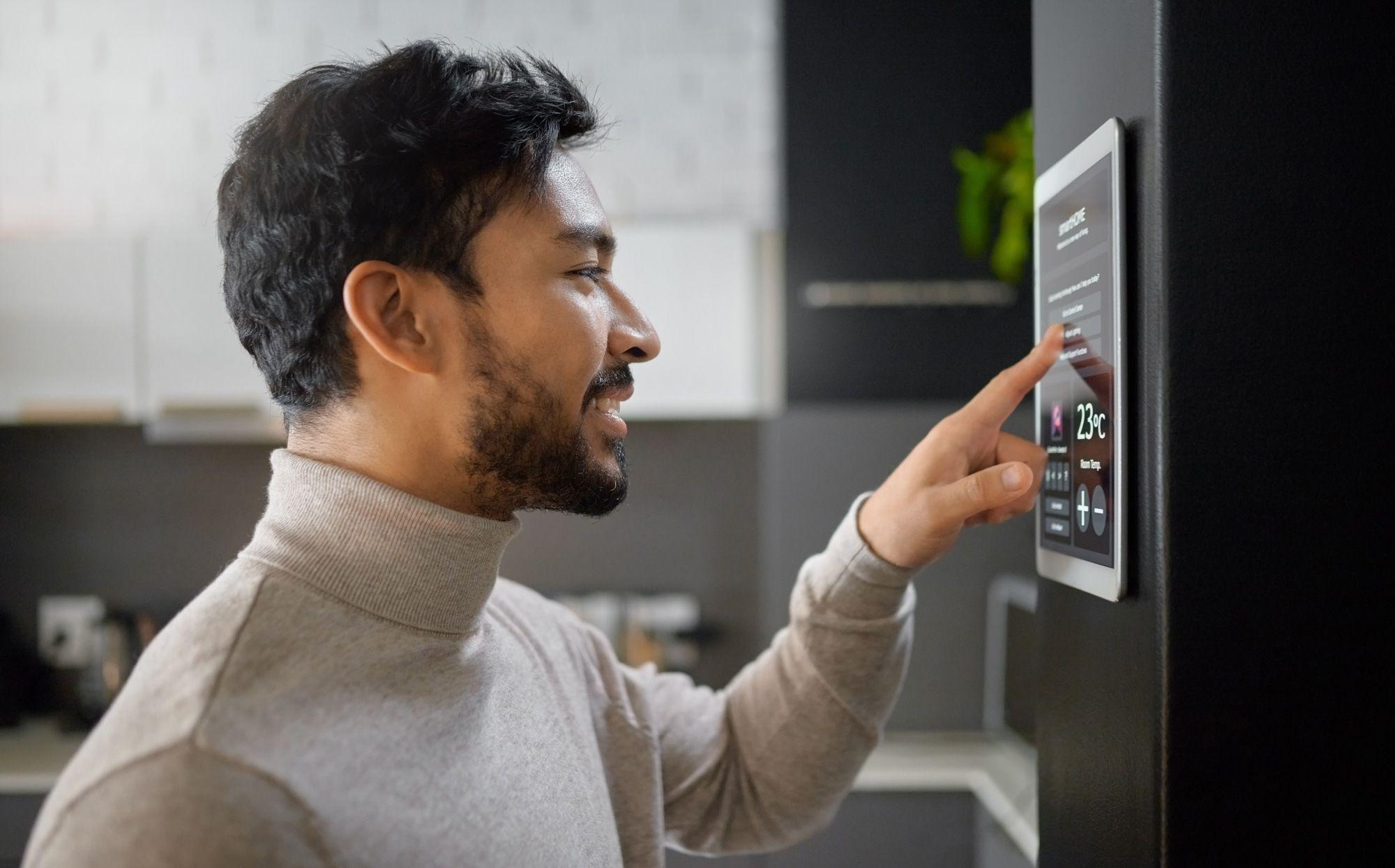 Mann bedient Touchscreen am Smart-Kühlschrank