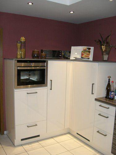 Unsere Referenzen — Hochglanz-creme Backofenturm mit Mikrowelle vor bordeauxfarbener Wand