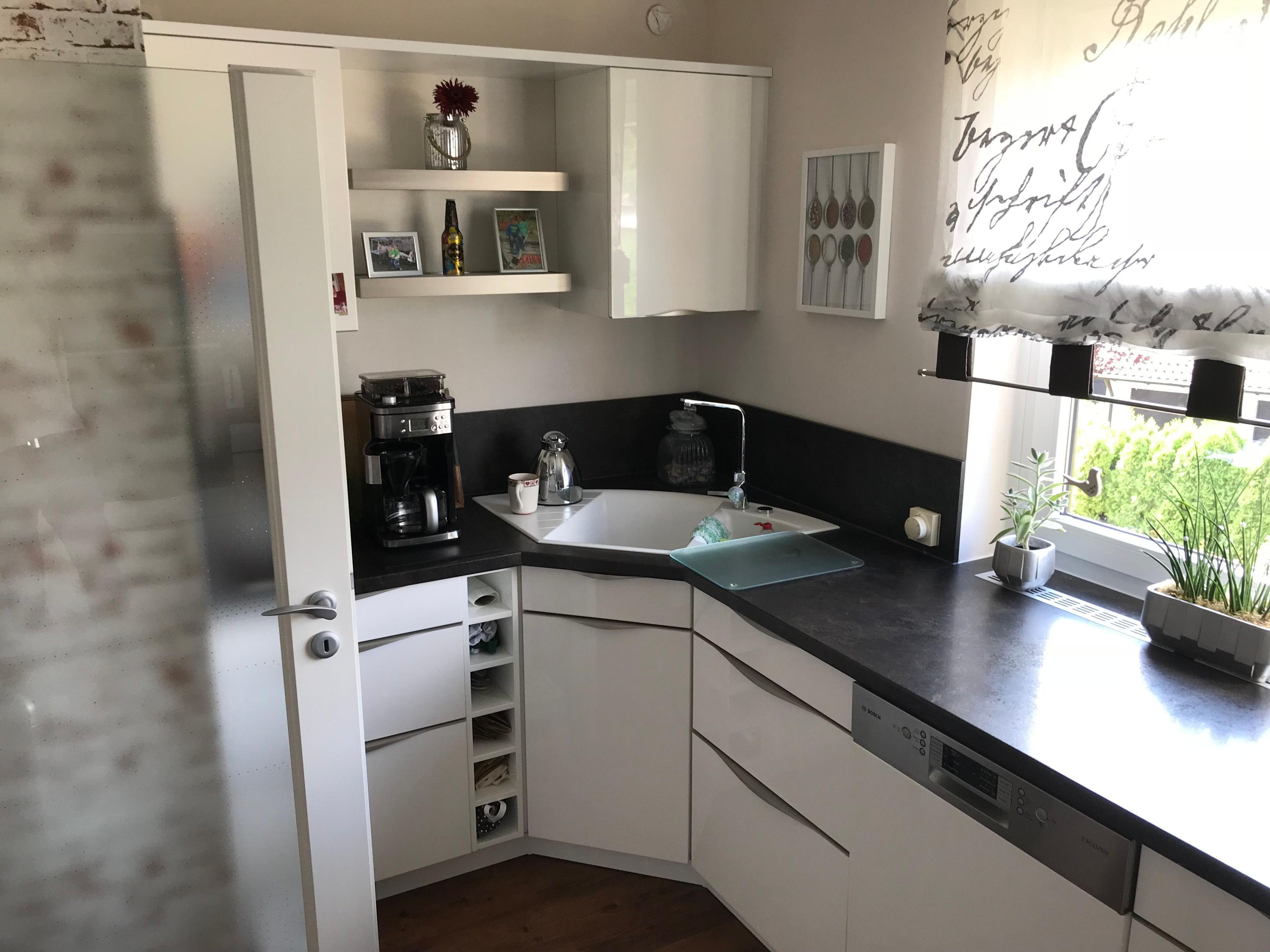 Unsere Referenzen — Weiße Küche mit Filterkaffeemaschine, offenen Regalen und Eckspüle