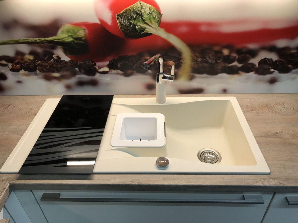 Unsere Ausstellung in Bischberg — Detail Granitspüle creme mit Glas-Abdeckung vor Chili-Motiv-Wand