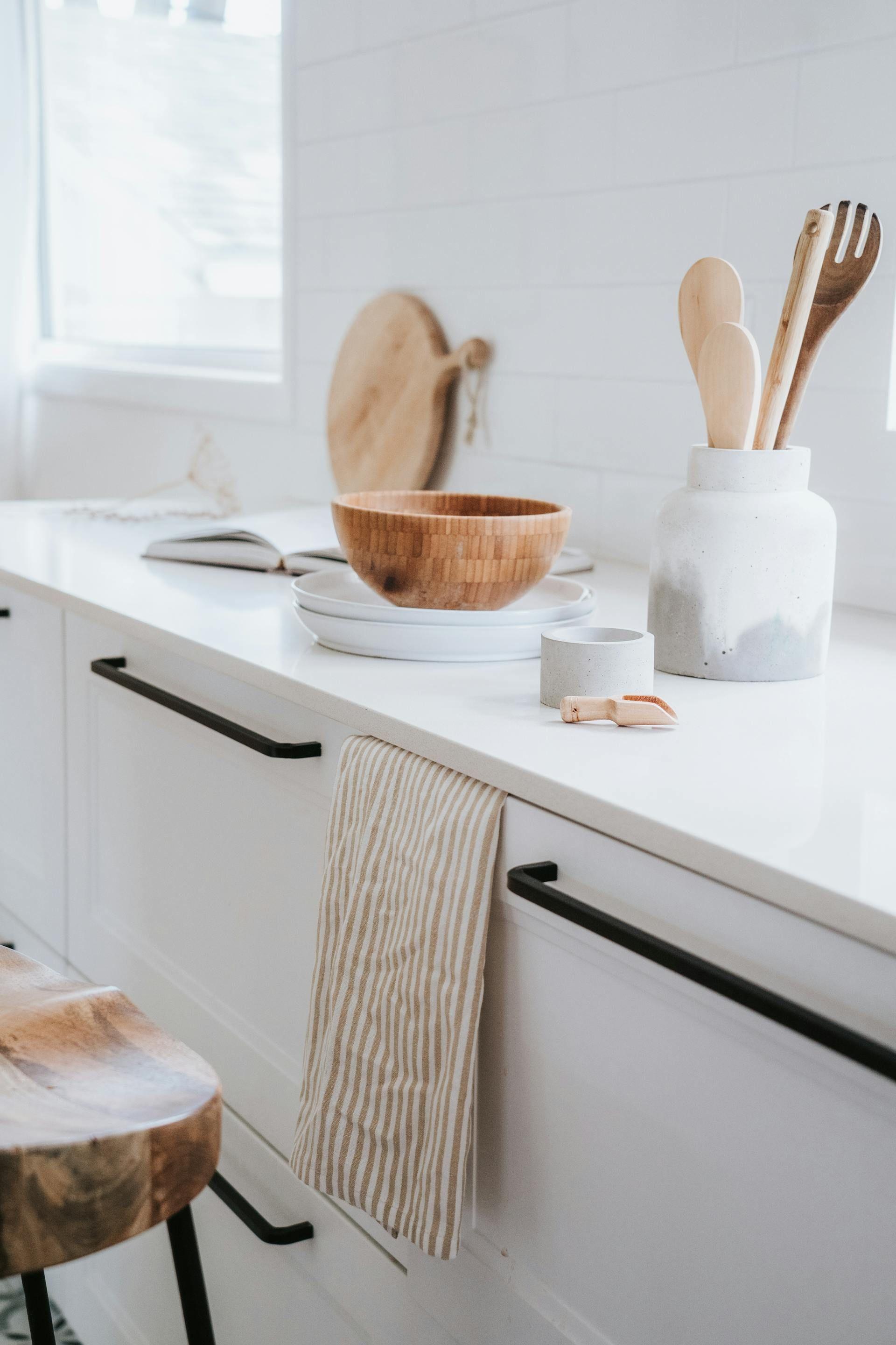 Helle Keramik-Küchenarbeitsplatte in gemütlicher Küche mit Holzaccessoires.