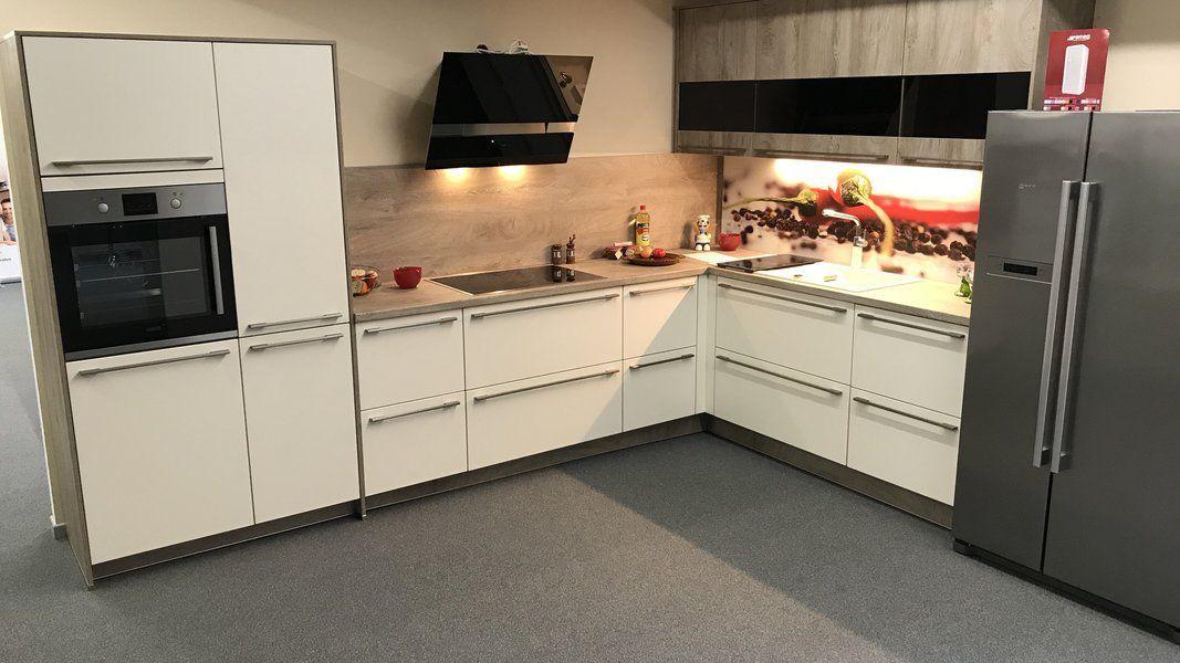 Showroom-Küche in Weiß mit Beton-Optik-Theke, Edelstahlkühlschrank und Beleuchtungs-Akzenten